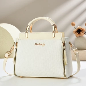 Sac à main blanc élégant avec texture tissée et logo en métal doré sur présentoir