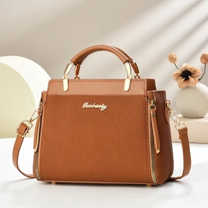 Sac à main marron caramel avec texture tressée, détails dorés et bandoulière