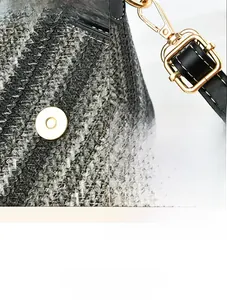 Detail of woven texture, magnetic closure and golden metal hardware on crossbody bag