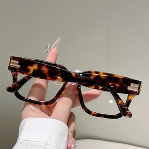 Detail of tortoise shell square frames with gold metal accents on the temple hinges