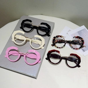 Detail of five irregular geometric glasses in black, cream, pink, and tortoiseshell frames