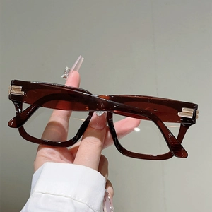 Detail of retro amber square frame glasses with elegant golden hinge metal accents
