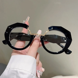 Irregular black frame glasses with gold bridge and heart diamond detail close-up