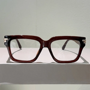Detail of dark brown square glasses frame with silver hinge accents on minimalist surface