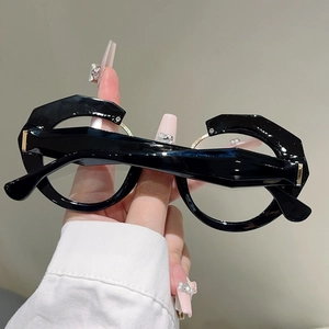 Close-up of black irregular polygon frame glasses with unique metal ring detail