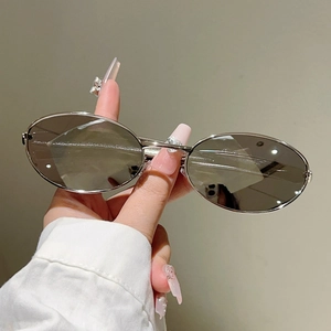 Détail de lunettes de soleil ovales argentées avec branches métalliques épurées