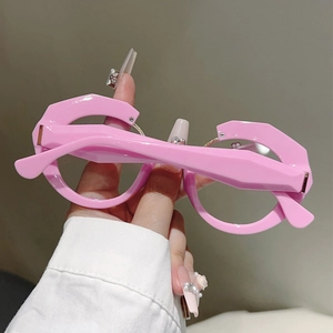 Close-up of bright pink irregular geometric eyeglass frame with Y2K aesthetic style