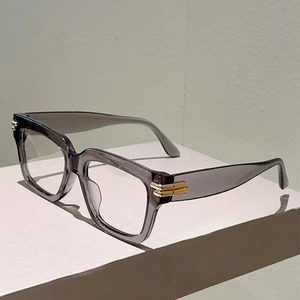 Macro detail of dark gray translucent square frame glasses with golden hinge accents