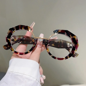 Macro detail of irregular round tortoiseshell eyeglass frames with gold metal hinges