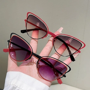 Détail de lunettes de soleil œil-de-chat rouges et noires avec design en métal ajouré