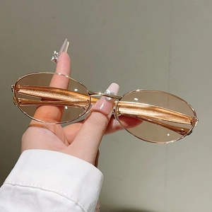 Détail de lunettes de soleil ovales vintage avec branches dorées dauphin et verres ambre