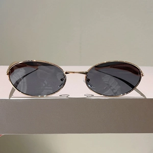 Détail du double pont classique et de la monture en métal doré des lunettes de soleil ovales