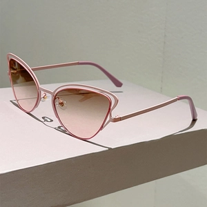Détail de lunettes de soleil œil de chat roses avec monture en métal évidé et verres dégradés
