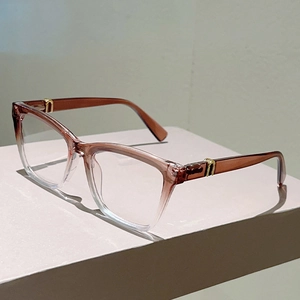 Detail der eckigen Brille mit bernsteinbraunem Verlauf und eleganten goldenen Metallakzenten