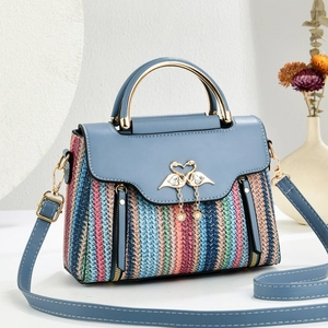 Colorful woven crossbody bag with blue leather handle and gold swan pearl clasp detail