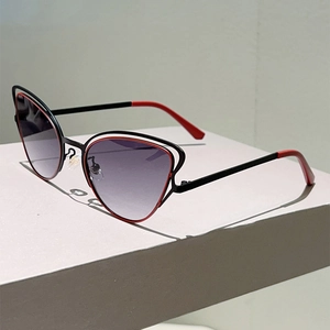 Détail des lunettes de soleil œil-de-chat avec monture rouge évidée et verres dégradés