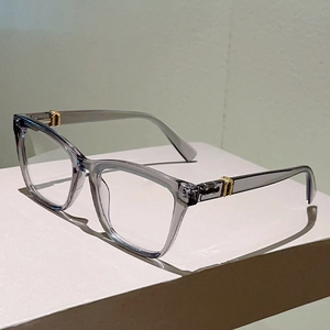 Detailansicht der transparent grauen quadratischen Brillenfassung mit goldenen U-Metallscharnieren