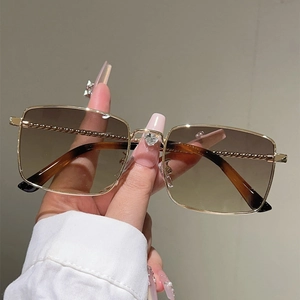 Detail of gold metal bridge with heart crystal and twisted rope textured temples on sunglasses