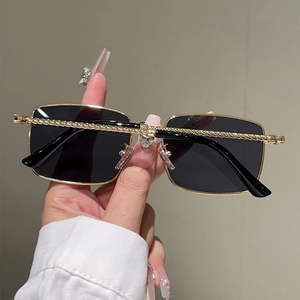 Detailed view of square gold metal sunglasses with textured rope temples and dark lenses