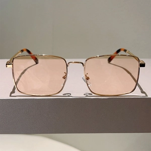 Minimalist square gold metal sunglasses with orange lenses and tortoiseshell temple tips