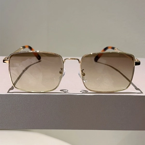 Detailed macro view of square gold metal sunglasses with orange gradient lenses