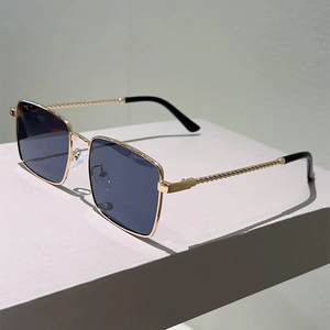 Square gold metal sunglasses with blue lenses and decorative twisted texture on temples
