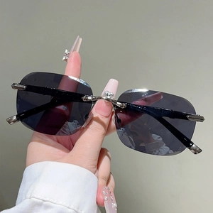 Close-up of rimless sunglasses with heart crystal detail and bamboo-style metal temples