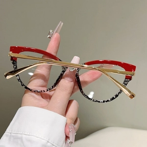 Nahaufnahme der Katzenaugen-Brille mit rotem Rand und schwarz-weiß gemustertem Detail