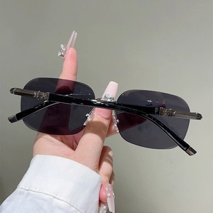 Close-up of frameless sunglasses featuring black temples and silver star metal embellishments