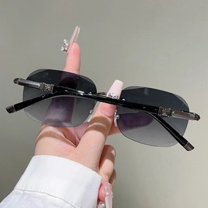 Detail view of rimless sunglasses with silver star ornament on the black temple hinge