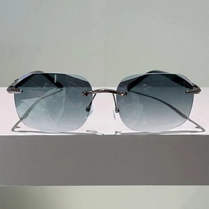 Close-up of rimless gradient gray lenses and dark metal bridge on punk sunglasses