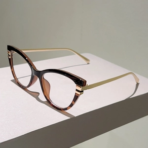 Detail der Katzenaugen-Brille mit Schildpatt-Muster und goldenen Metallbügeln