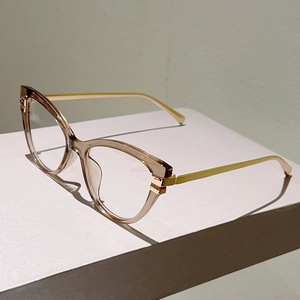 Detailansicht der Champagner Cat-Eye-Brille auf weißem Stein mit goldenen Metallbügeln