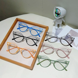 Macro shot of stylish hollow cat-eye metal frames in six vibrant colors on a wooden tray