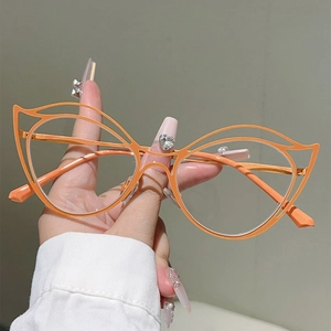 Detail of vibrant orange hollow cat-eye metal frames and stylish cutout glasses