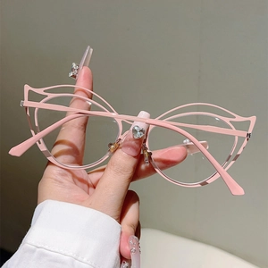 Detail of pink hollow cat eye frame glasses with metal butterfly-shaped cutout design