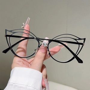 Detail view of black cat-eye hollow metal frames held by hand for a lightweight fashion look