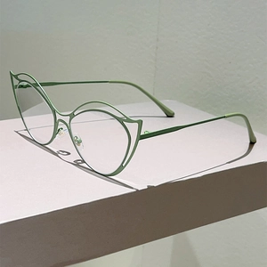 Detail of light green cat-eye frame featuring minimalist hollow metal line design