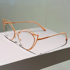 Detail of the orange metal cat-eye frames with hollow geometric lines and clear lenses