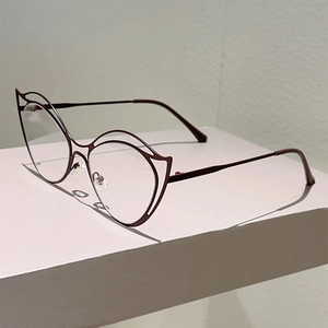 Detail of dark red cat-eye glasses with double-layered metal frame on a display stand
