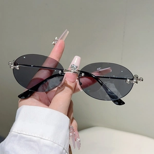 Gros plan de lunettes de soleil ovales sans monture avec strass cœur et perles argent