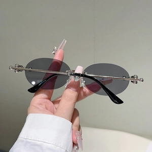 Détail de lunettes de soleil ovales sans monture, monture argentée et pont de nez en cœur