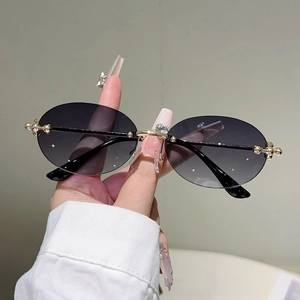 Vue détaillée de lunettes de soleil ovales sans monture avec branches à perles dorées