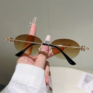 Détail des joints métalliques dorés et verres dégradés marron sur lunettes ovales