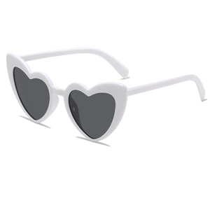 Top view of white heart-shaped sunglasses with dark lenses on a clean background
