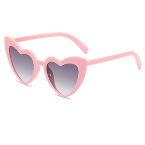 Close-up of bright pink heart-shaped sunglasses with stylish grey gradient lenses