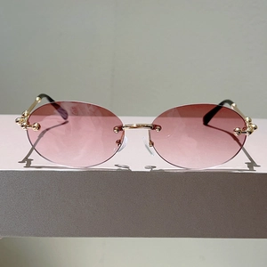 Détail de lunettes sans monture à verres dégradés roses avec perles métalliques dorées