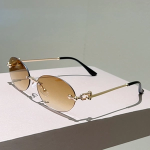 Détail de lunettes de soleil ovales avec branches chaînettes dorées et verres dégradés