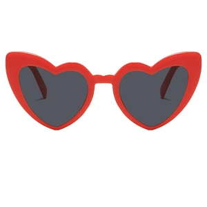Close-up of heart-shaped sunglasses with bold red plastic frames and dark lenses