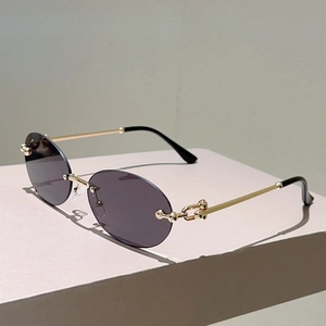 Détail des branches en métal doré avec maillons doubles billes sur lunettes ovales sans monture